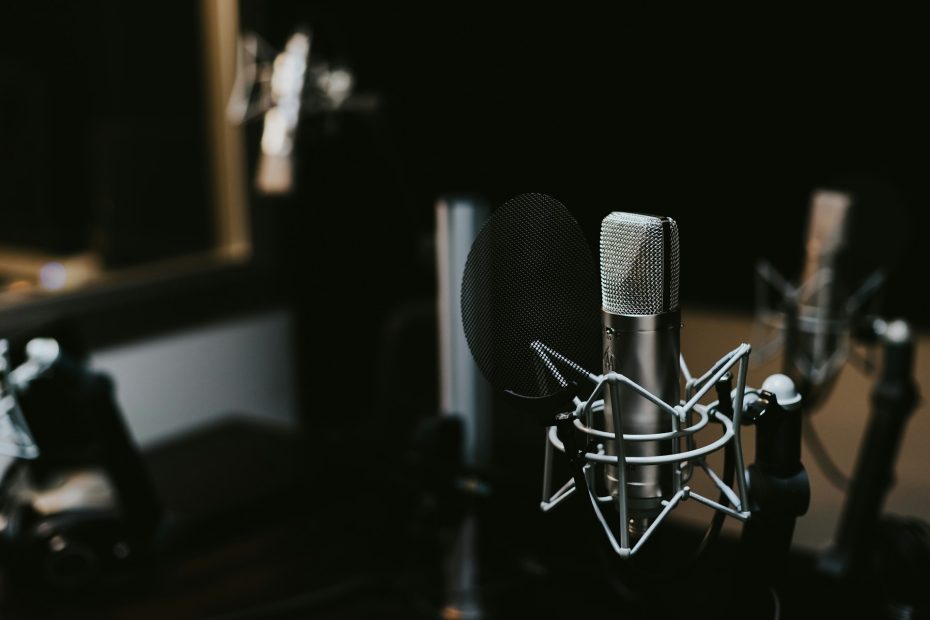 Photo of microphones and a desk in a recording studio.