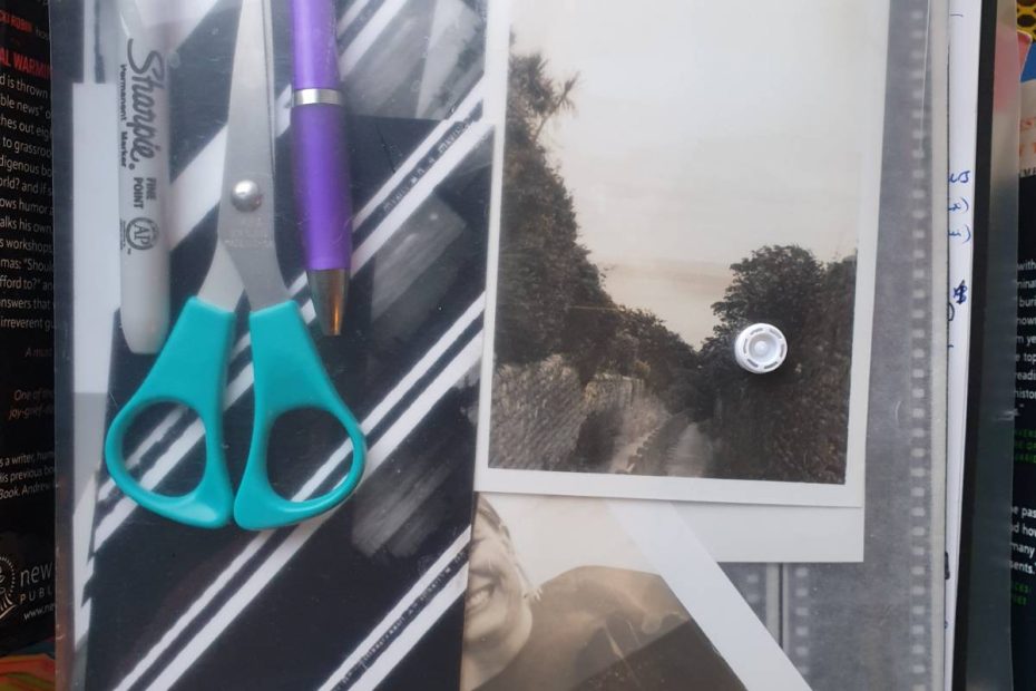 A transparent plastic folder contains a ballpen, a marker and a pair of scissors, as well as film negatives, some contact sheet test strips, and some prints of a landscape and you can see part of a portrait too.