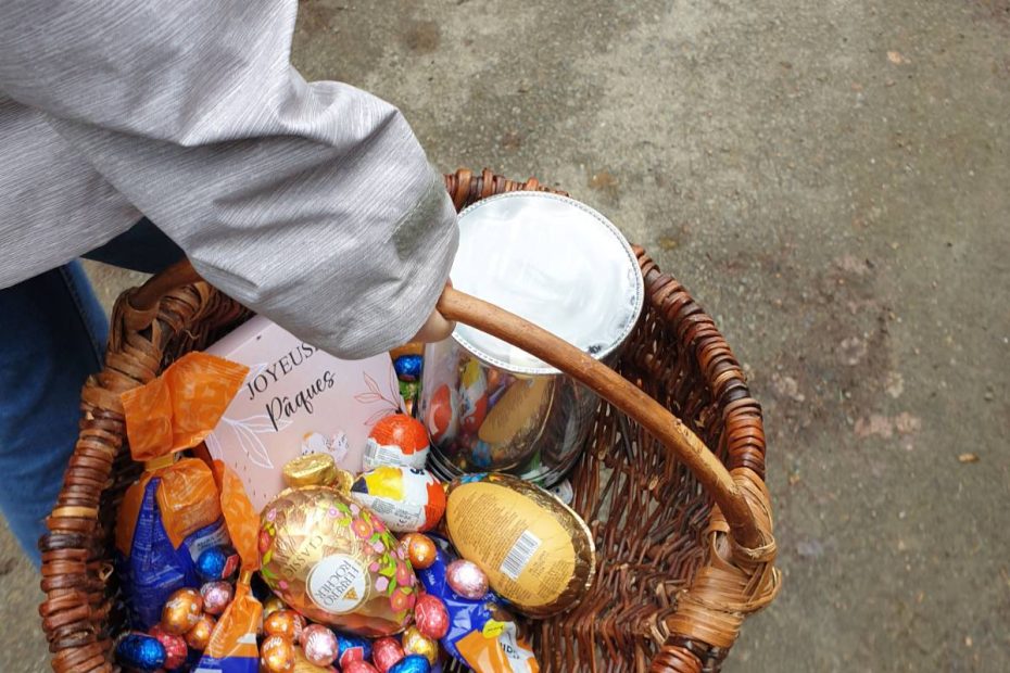 Someone (my friend) is carrying a large wicker basket - you can just see their arm and the basket - which is filled with fancy Easter chocolate eggs of all sizes.