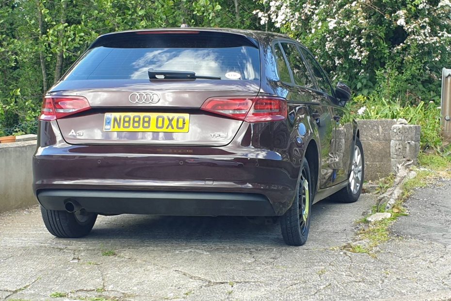My car which looks all neat with a newly repaired bumper but with the thin spare tyre where I changed the wheel after a flat.