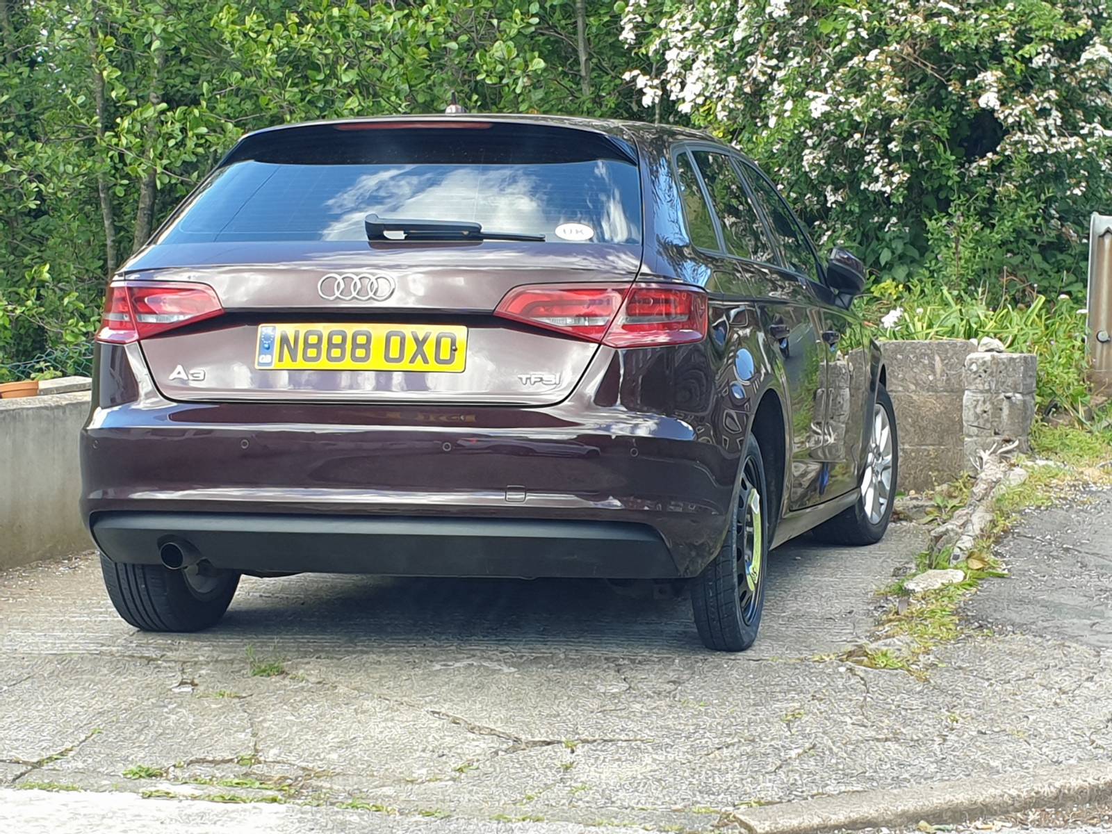 My car which looks all neat with a newly repaired bumper but with the thin spare tyre where I changed the wheel after a flat.