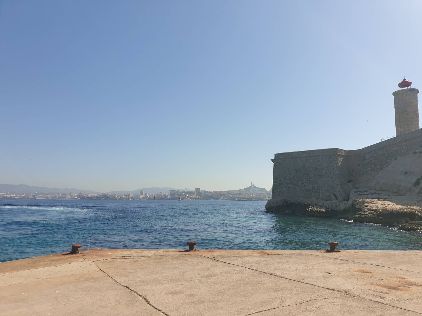 A view from the dock on the Ile d'If (where the Chateau d'If served as a prison and was the setting for the Count of Monte-Cristo), looking across the blue waters of the bay back towards Marseille.